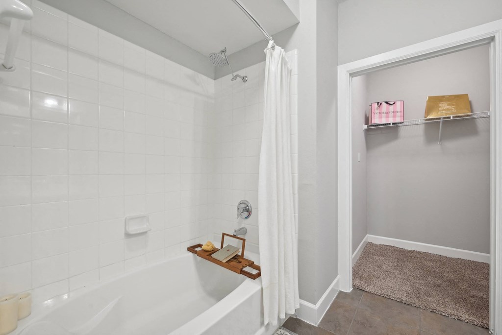 A white bathroom with a white tub and a white shower curtain.