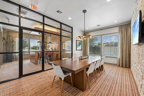 A conference room with a long table and chairs.