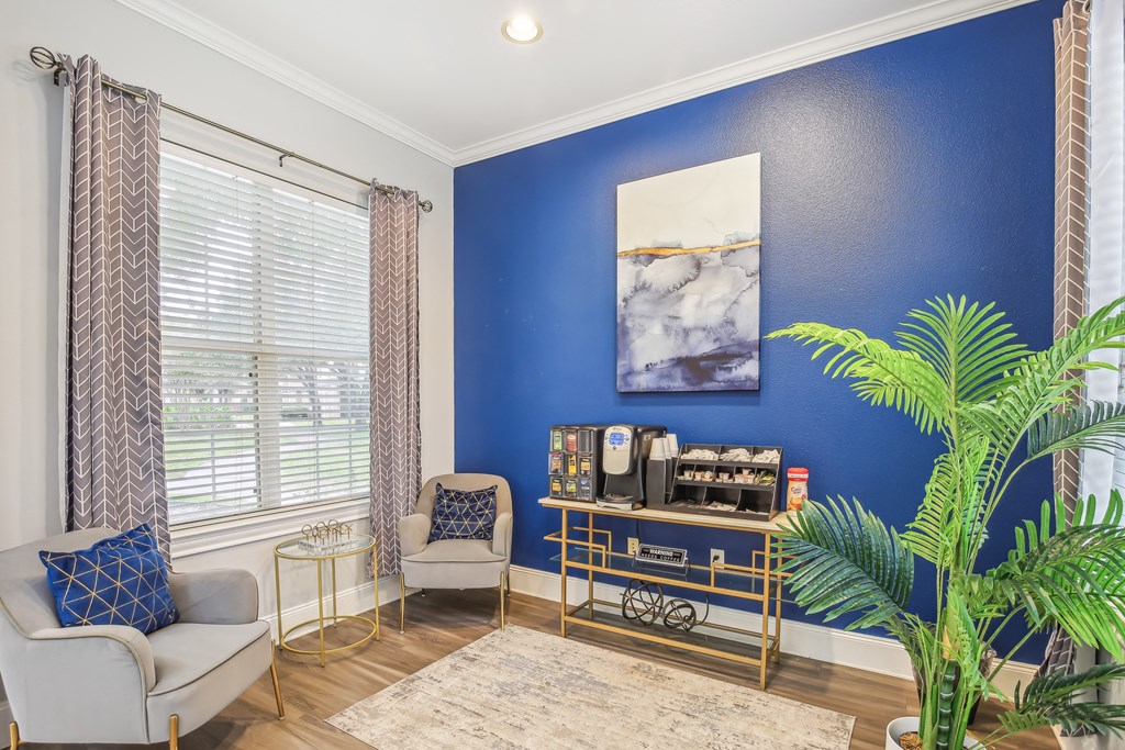 A living room with a blue wall and a painting of water.
