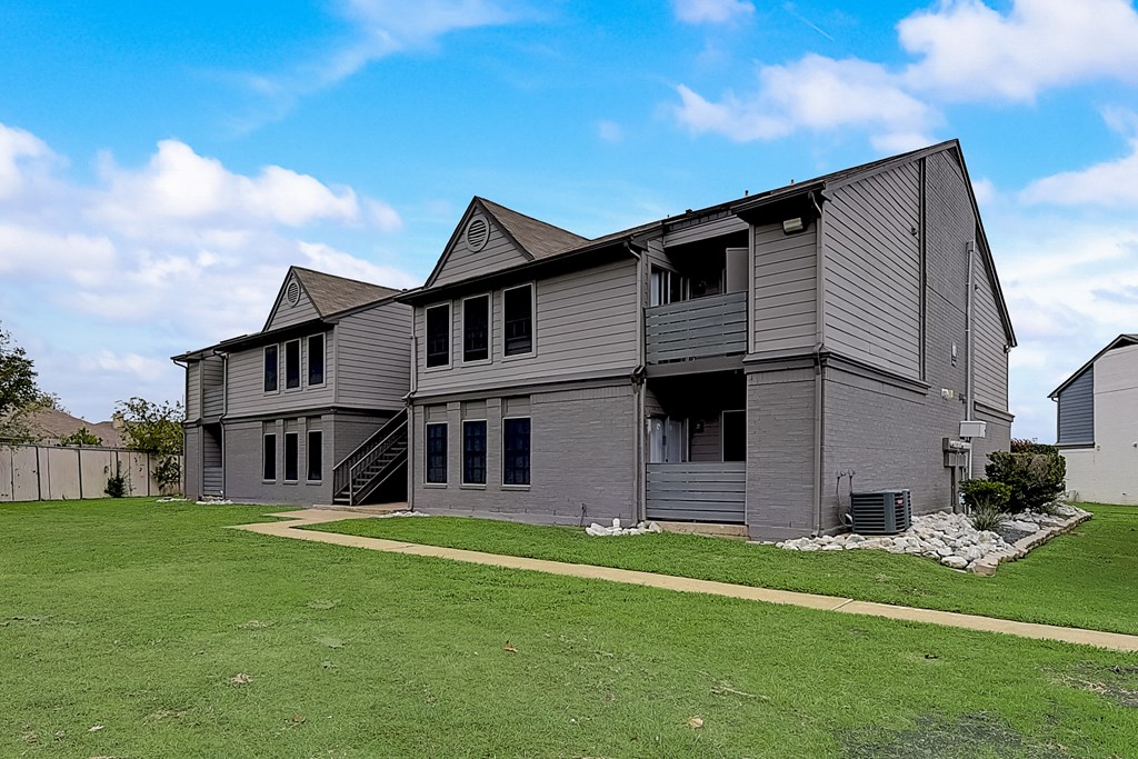 a large gray house with a lawn in front of it