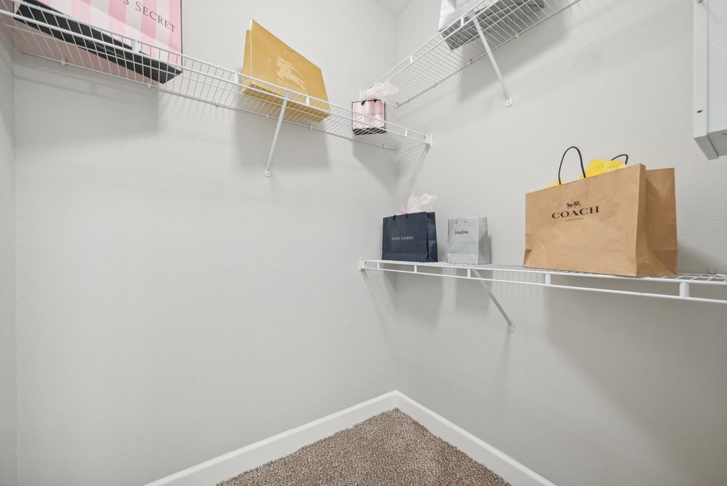 A room with a white wall and a shelf with a bag that says "The Coach" on it.
