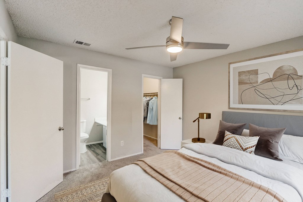 a bedroom with a large bed and a ceiling fan