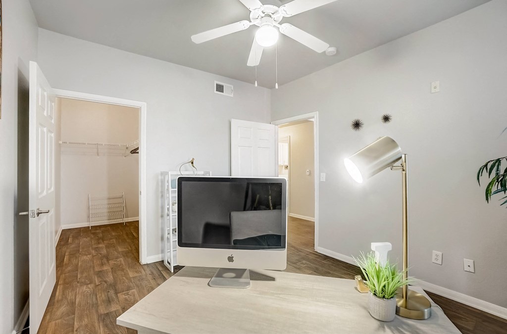 a living room with a tv and a ceiling fan