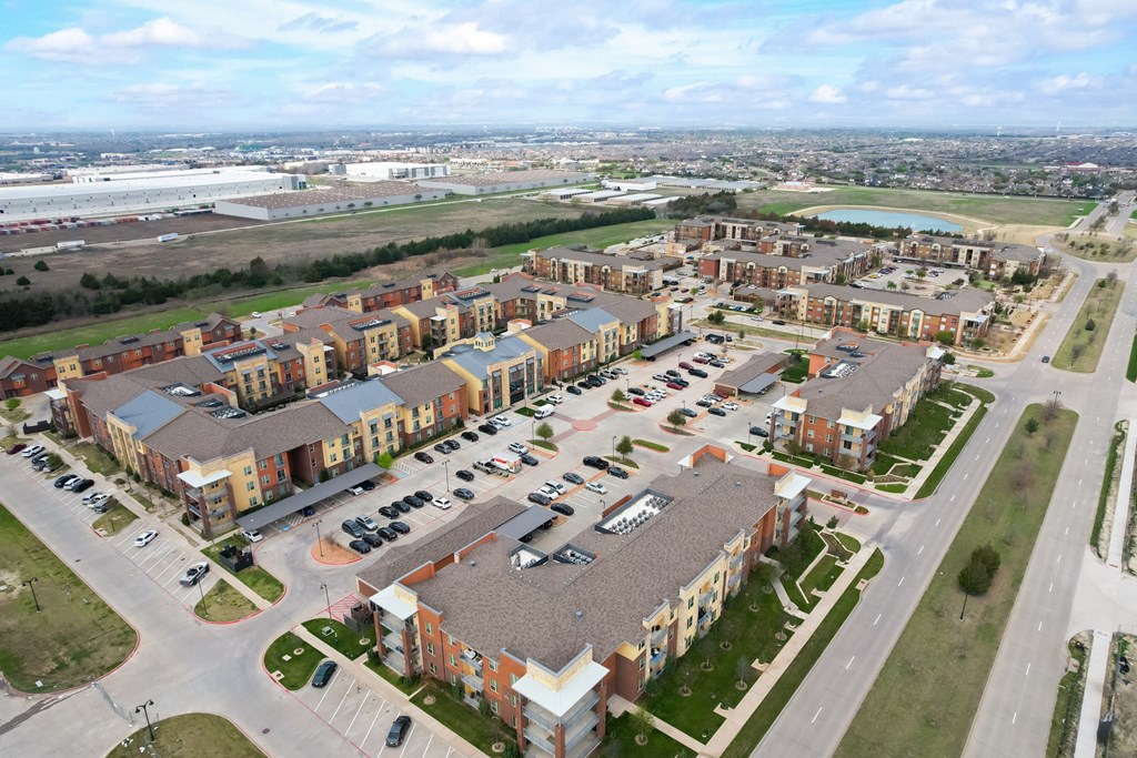 an aerial view of an apartment complex and parking lot