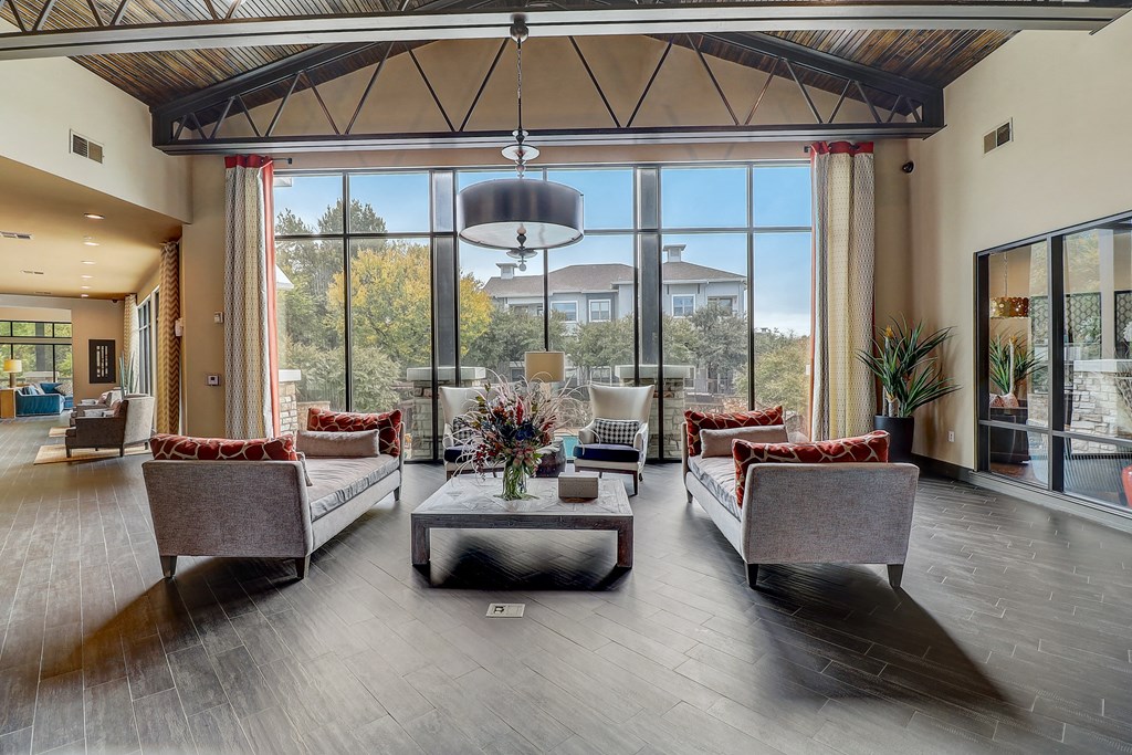 a large living room with couches and chairs and large windows