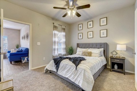 a bedroom with a bed and a ceiling fan