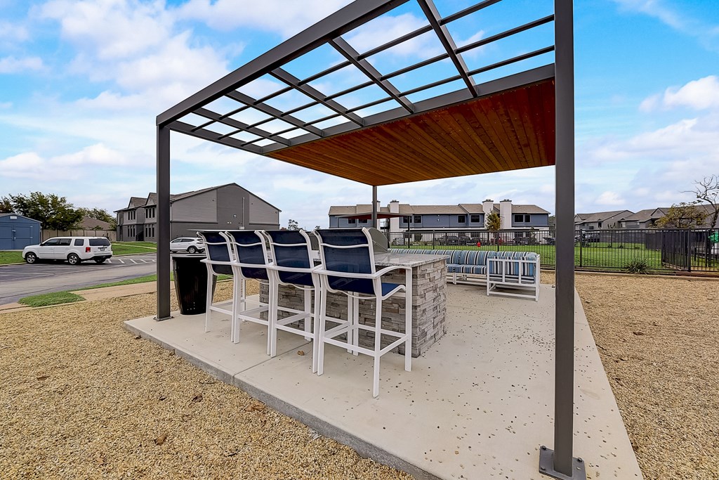 a patio with a table and chairs under a covered