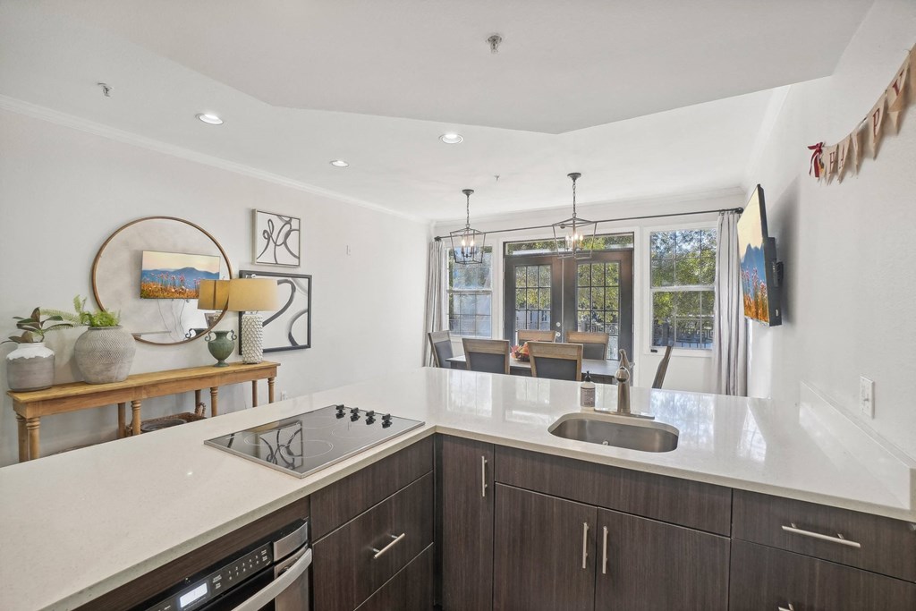 A modern kitchen with dark wood cabinets and a white countertop.