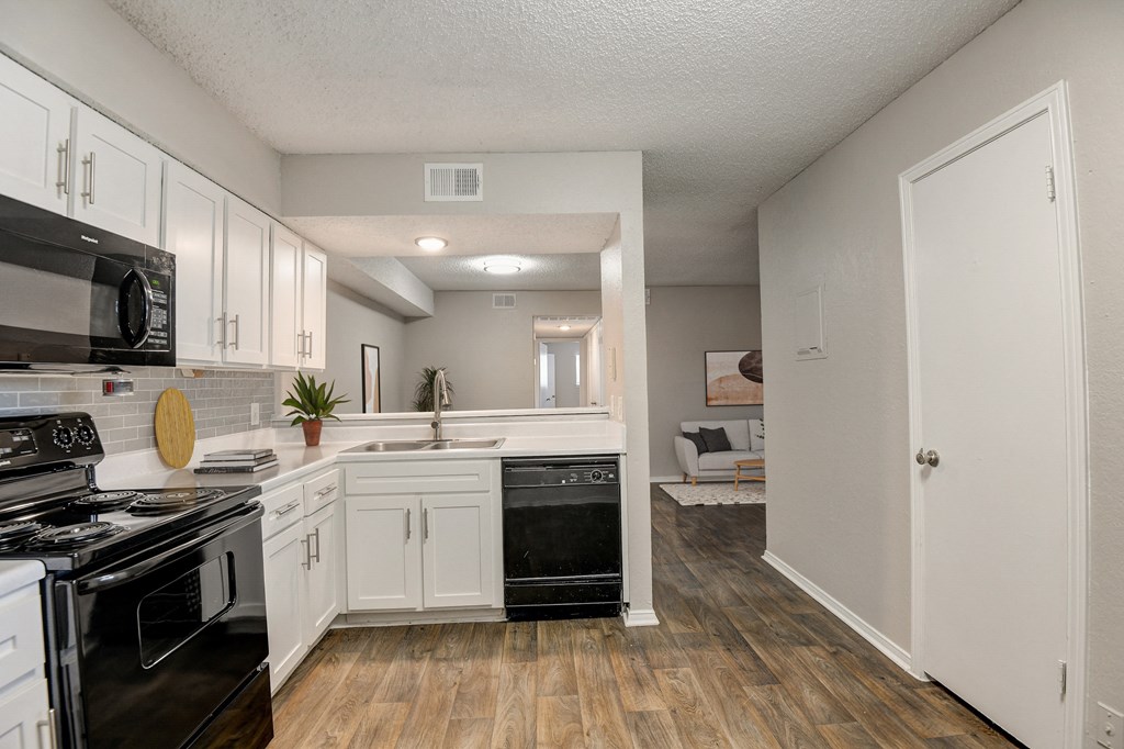 a kitchen with white cabinetry and black appliances