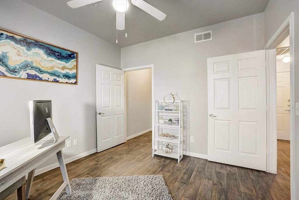 the living room of a home with white walls and wood floors
