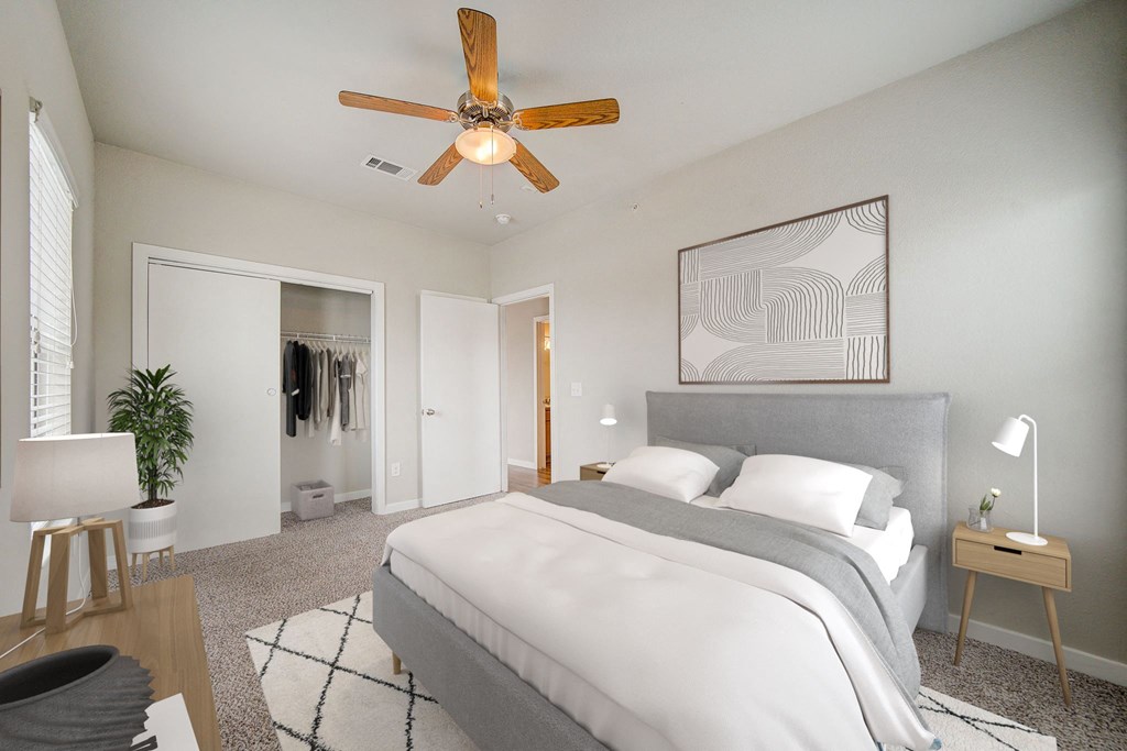 a bedroom with a large bed and a ceiling fan