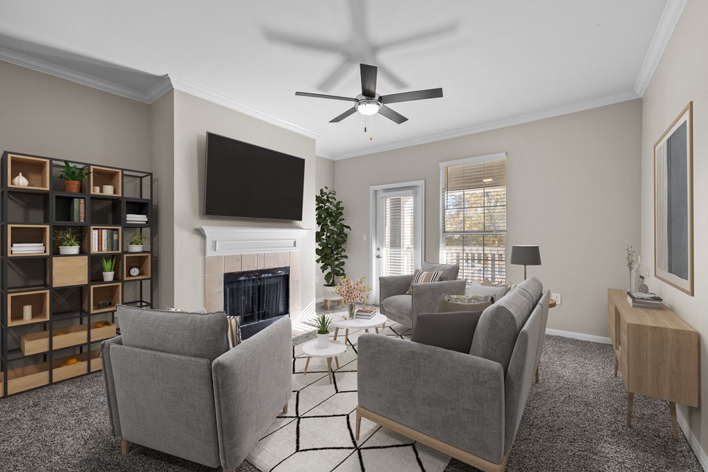 a living room with a ceiling fan and couches