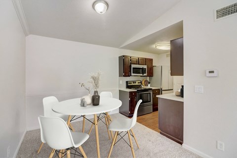 a dining room with a table and chairs next to a kitchen