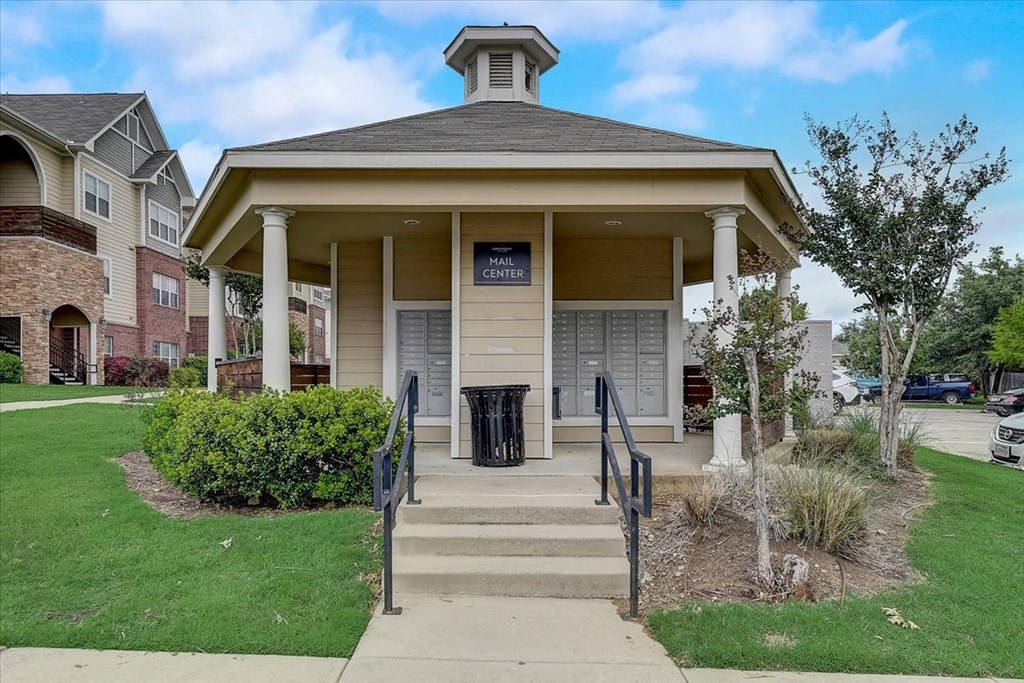 a building with stairs and a trash can in front of it