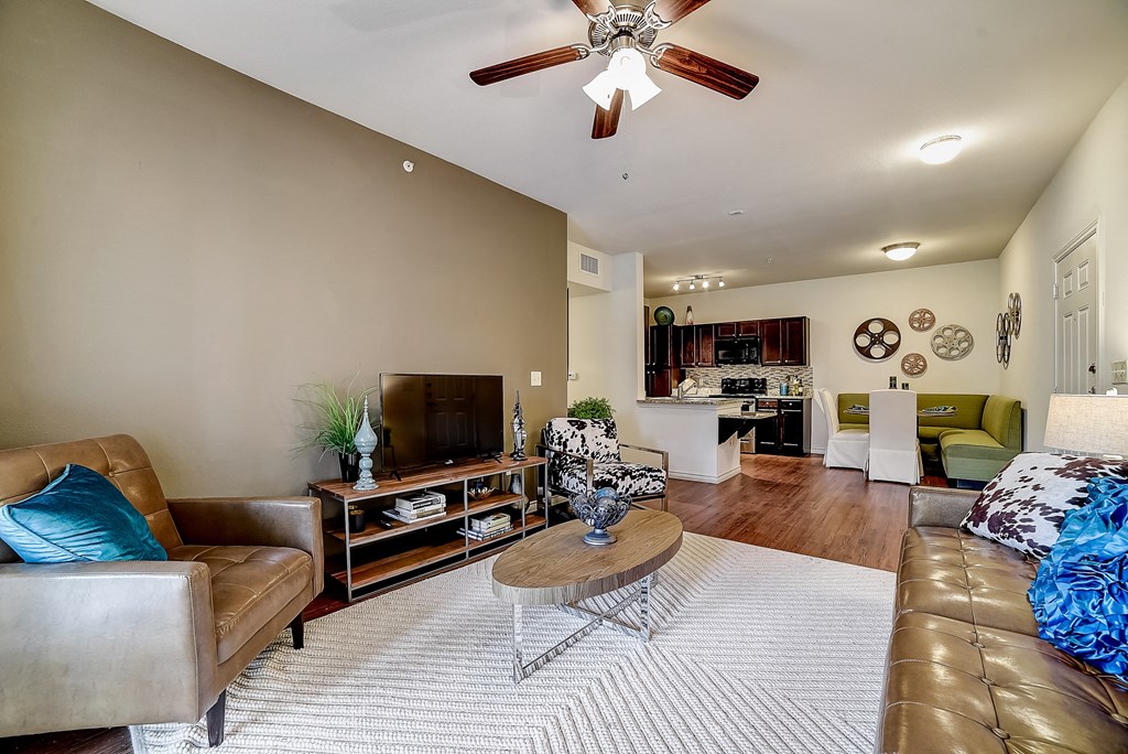 a living room with a ceiling fan and hardwood flooring