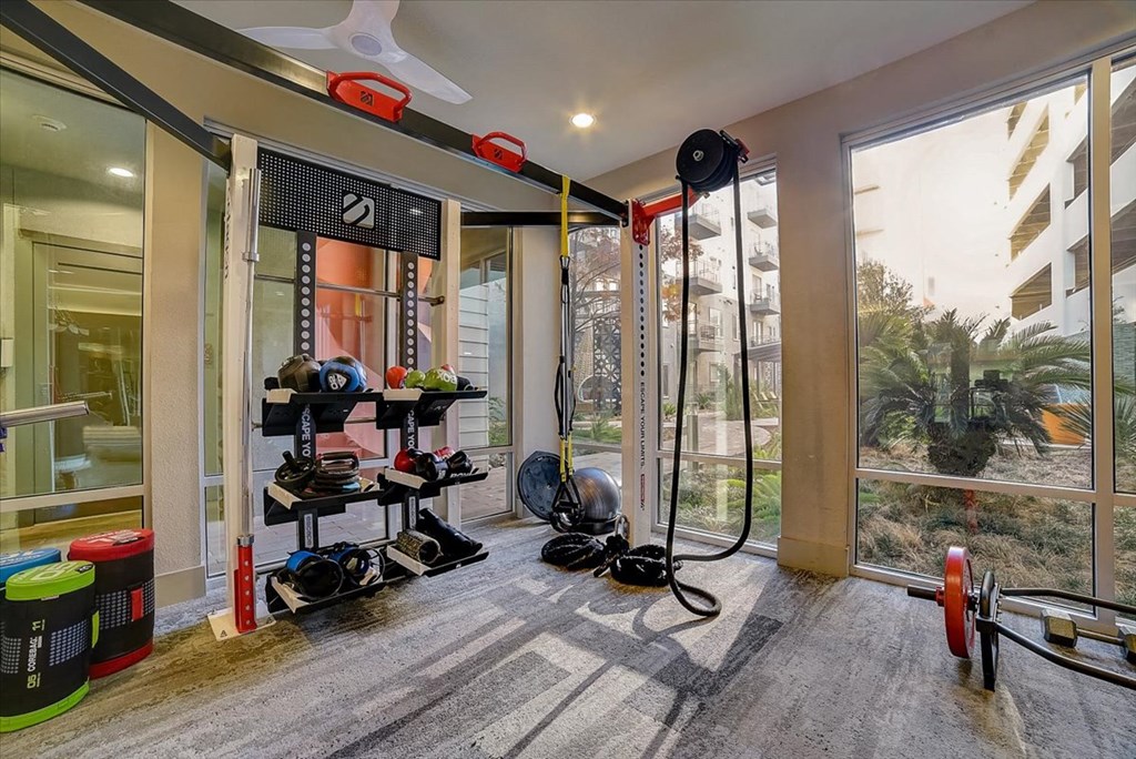 a home gym with a lot of equipment and a large window