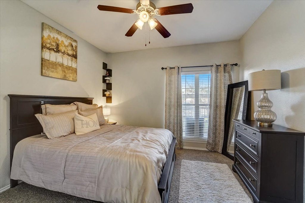 a bedroom with a bed and a ceiling fan