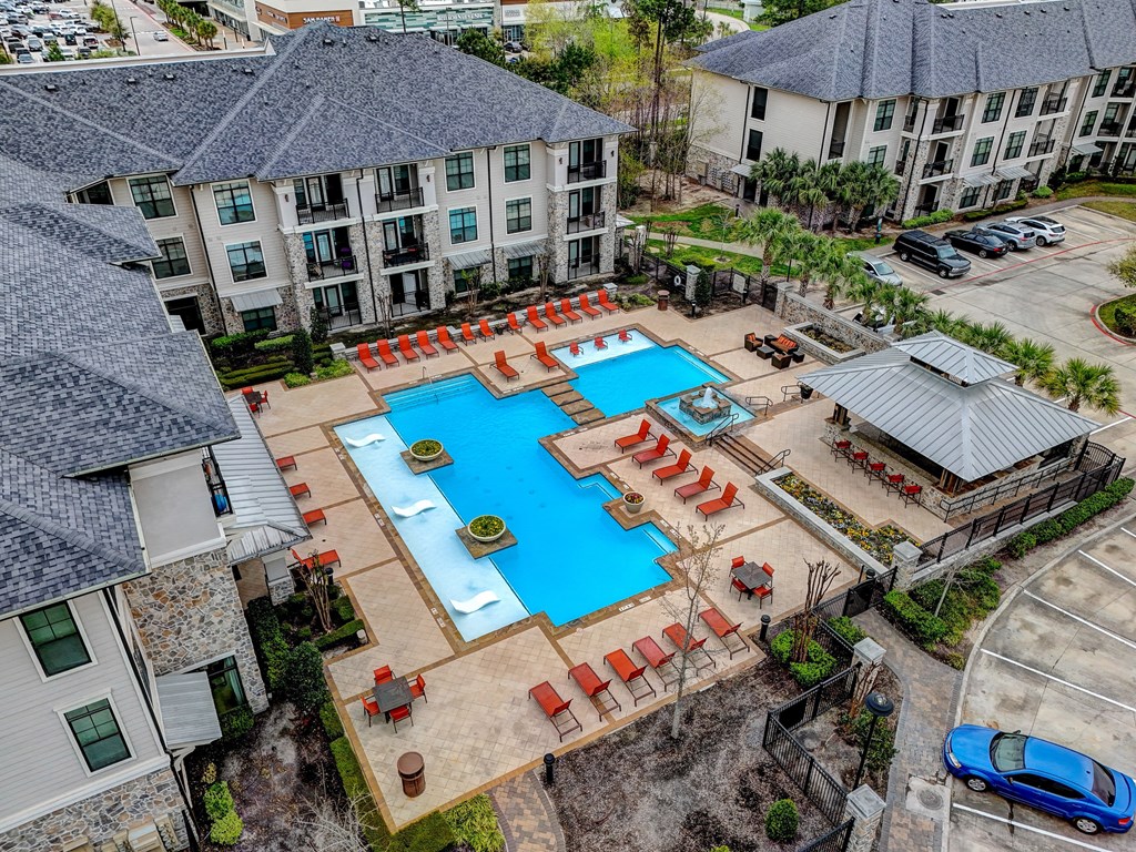 an aerial view of an apartment complex with a large swimming pool