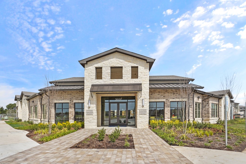 A modern building with a brick facade and a large glass entrance.