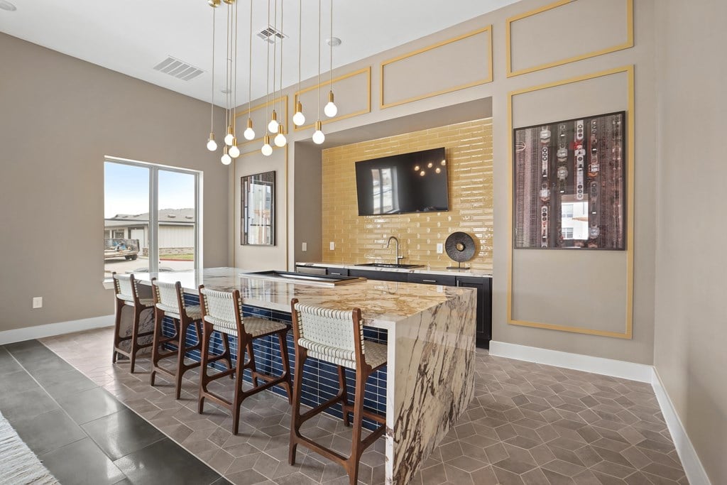 A modern kitchen with a bar area and a television mounted on the wall.