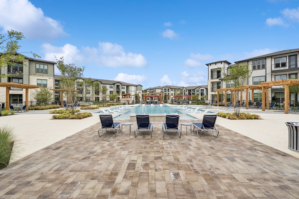 A large square with a pool in the middle and chairs around it.