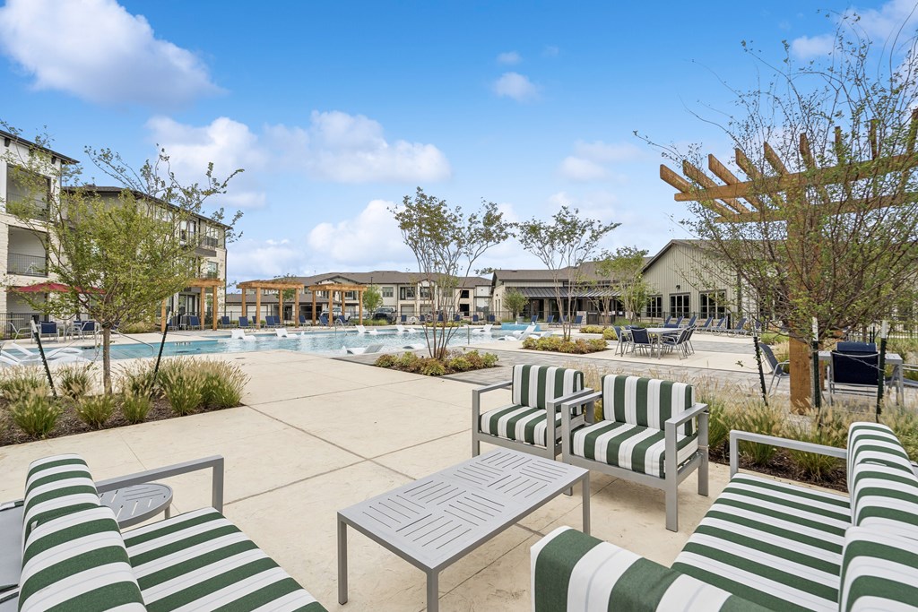 A sunny day at the poolside with green and white striped sun loungers.