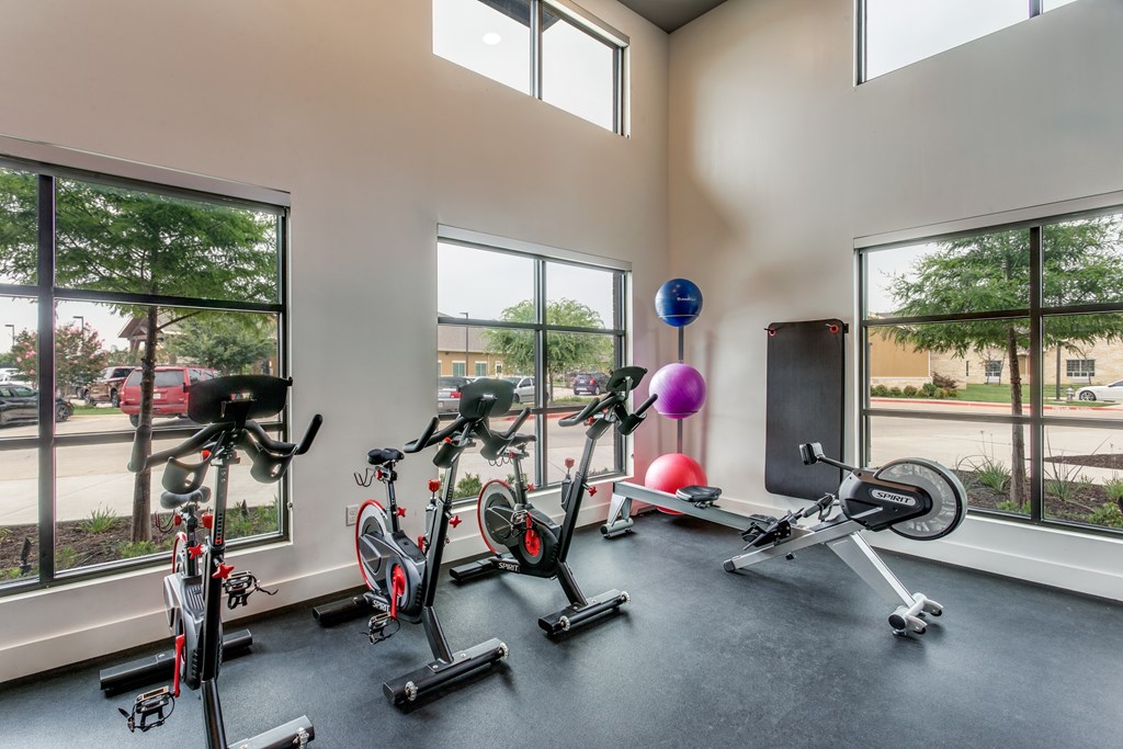 A room with exercise equipment and windows.