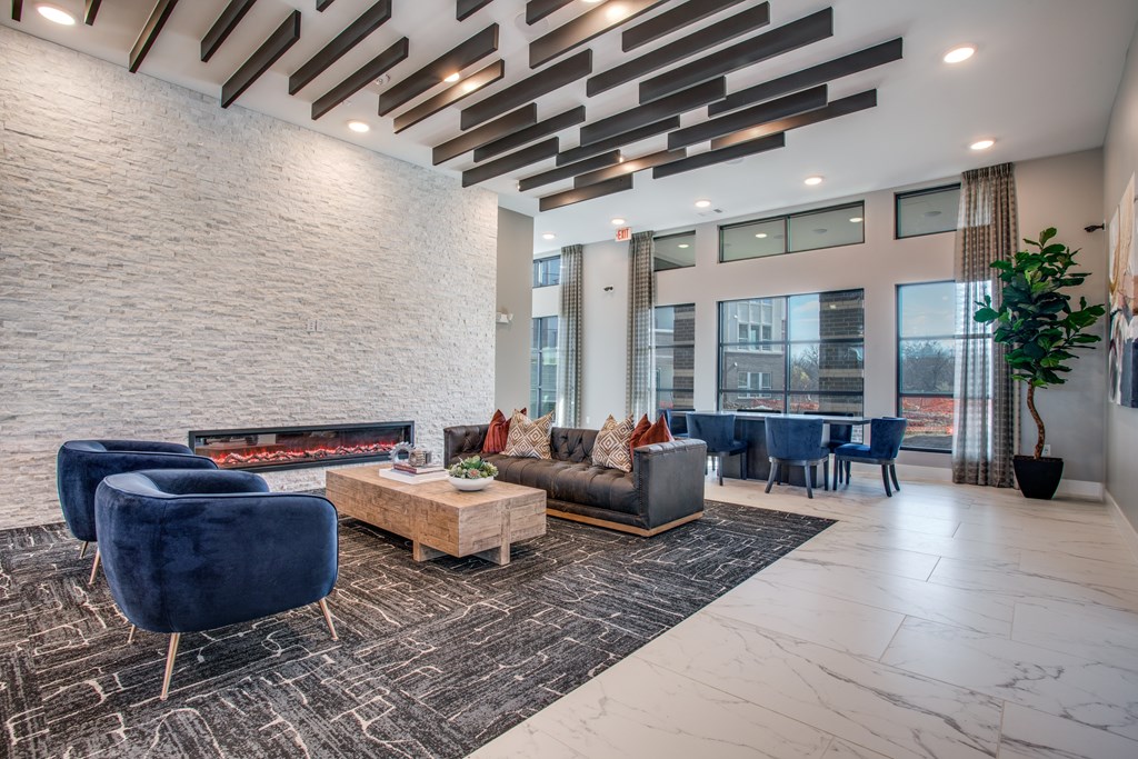 A modern living room with a fireplace and blue chairs.