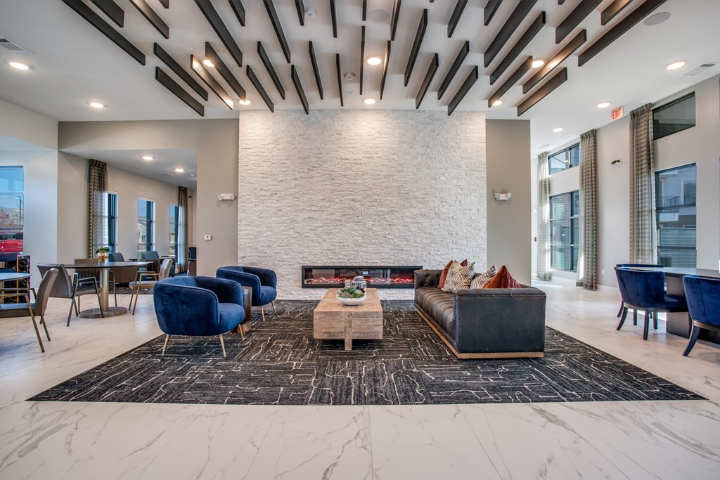 A modern living room with a fireplace and blue chairs.