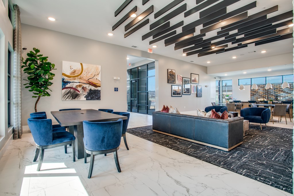 A modern living room with a dining table and blue chairs.