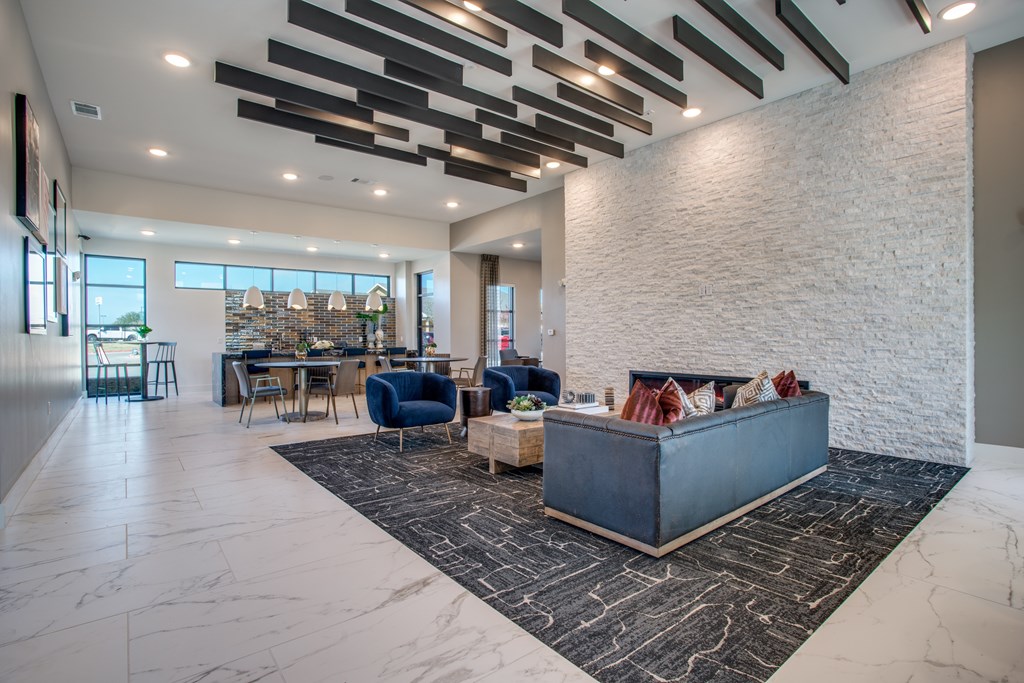 A modern living room with a large grey couch and a black and white rug.
