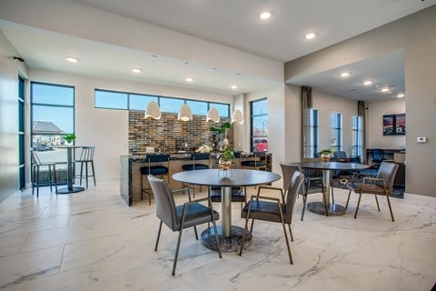 Community dining area with café tables, chairs, and adjacent serving counter.