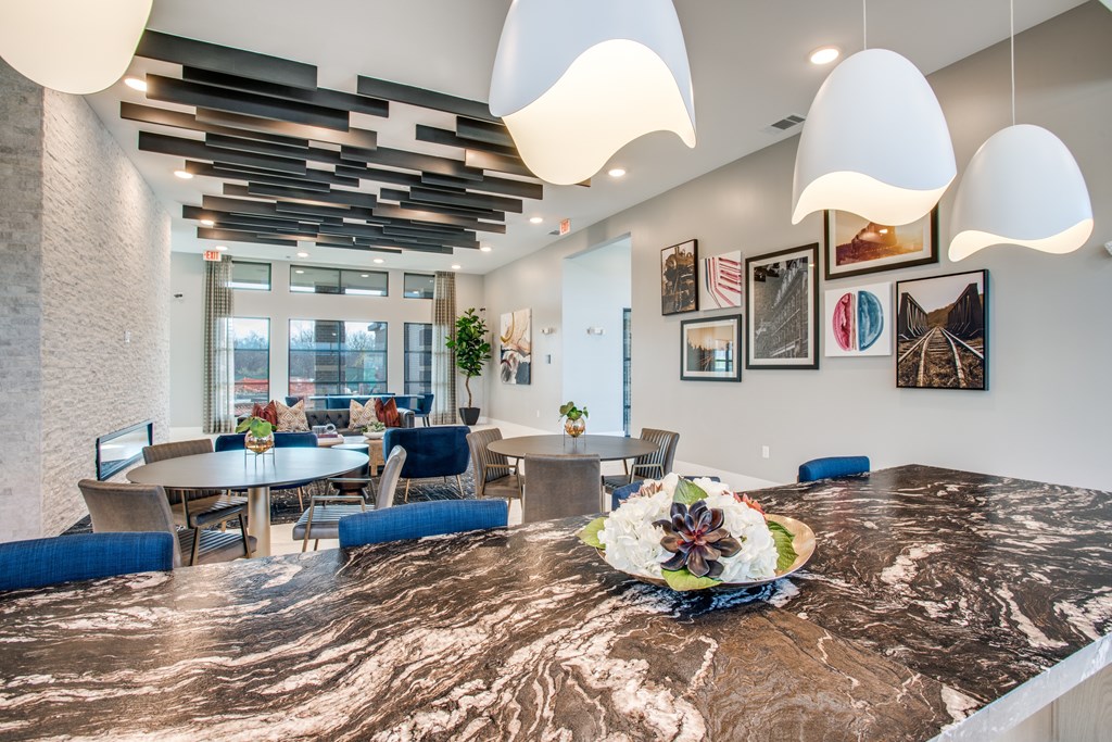 A dining room with a marble table and blue chairs.