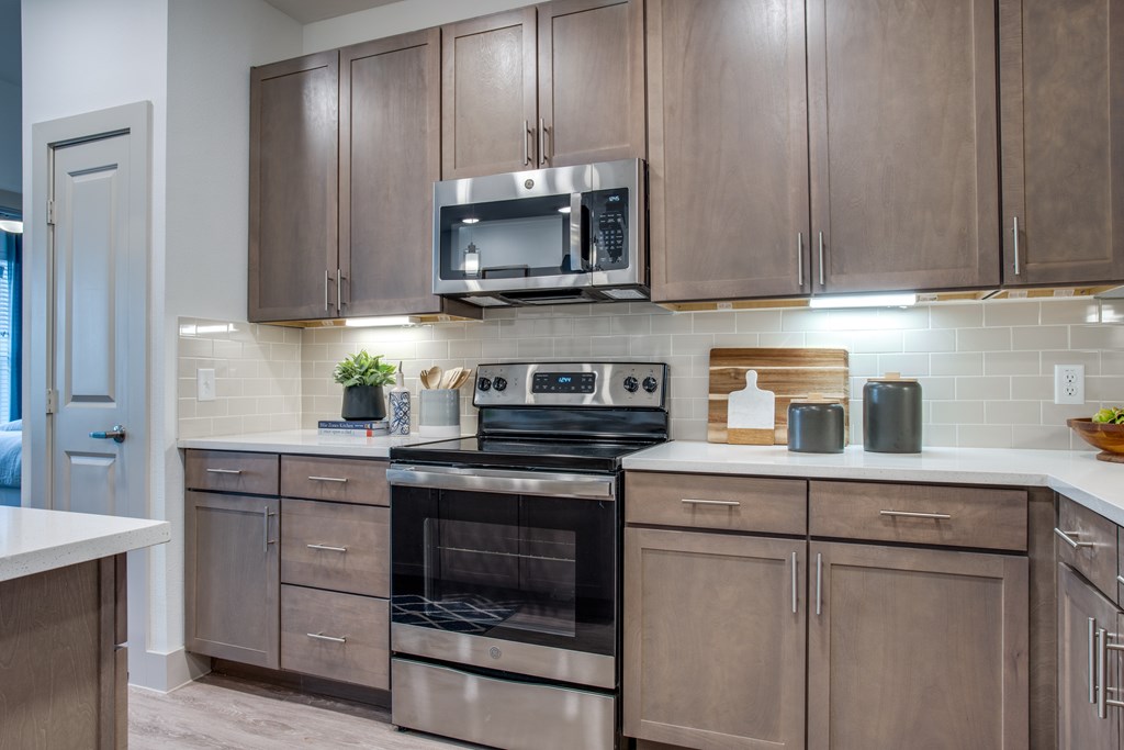 A modern kitchen with wooden cabinets and stainless steel appliances.