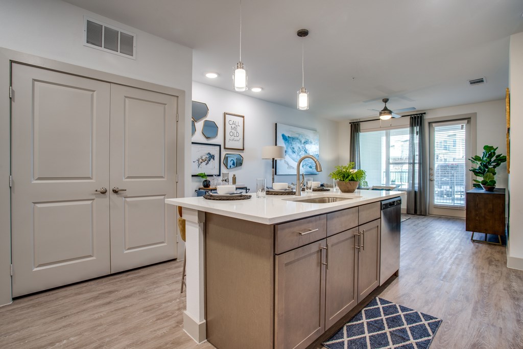 A kitchen with a white counter top and wooden cabinets.