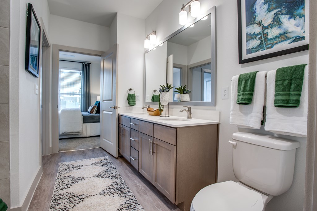 A bathroom with a white toilet and a mirror above the sink.