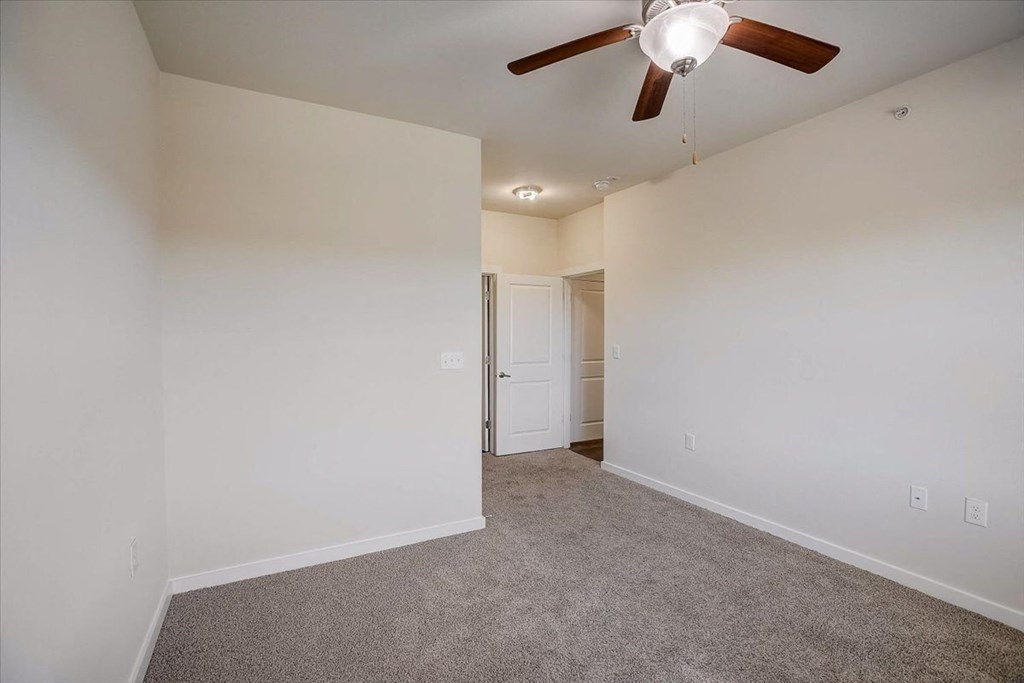 a bedroom with carpet and a ceiling fan