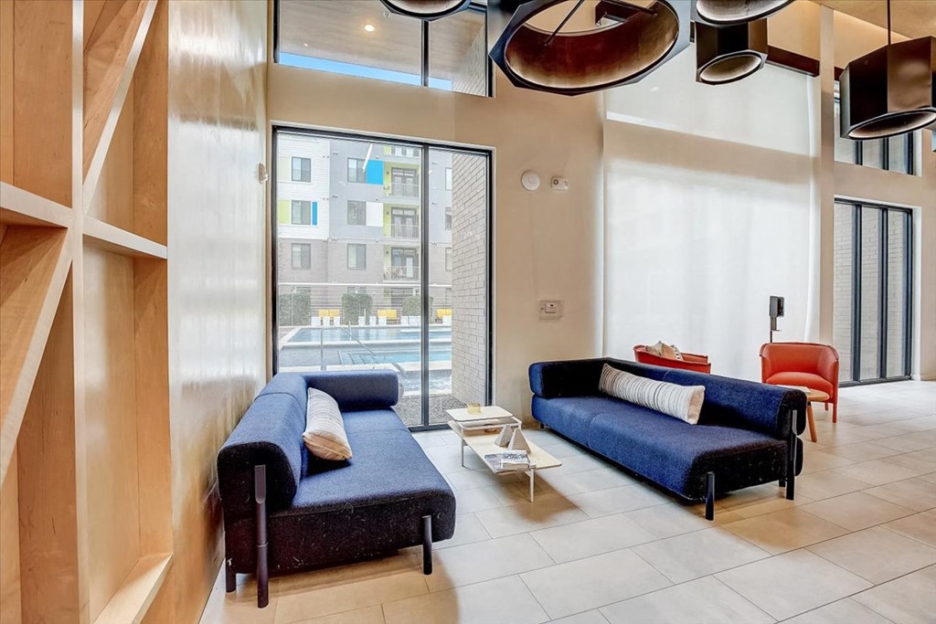 a living room with blue couches and a large window