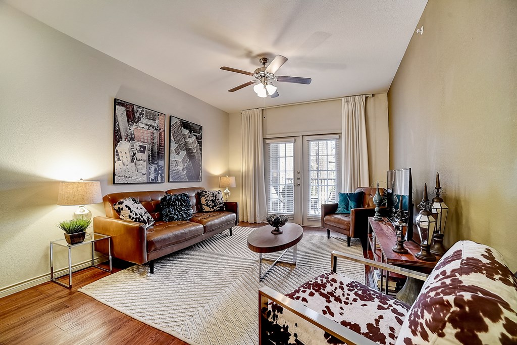 a living room with a ceiling fan and hardwood floors