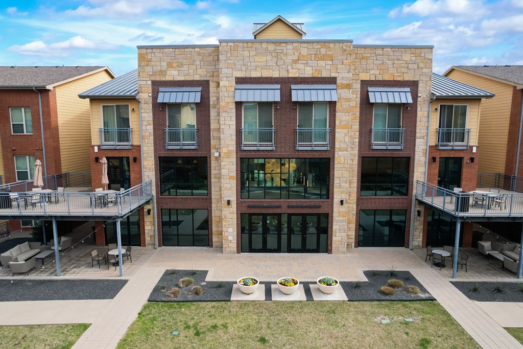 an exterior view of a brick building with balconies and a courtyard