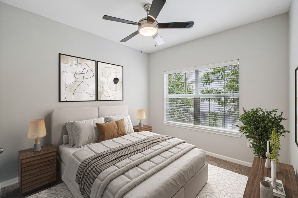 A bedroom with a bed, two lamps, a ceiling fan, and a window with blinds.