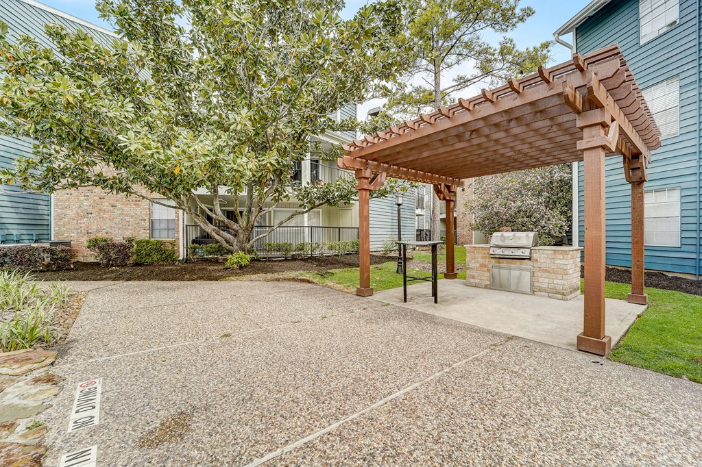 a patio with a pergola in front of a house