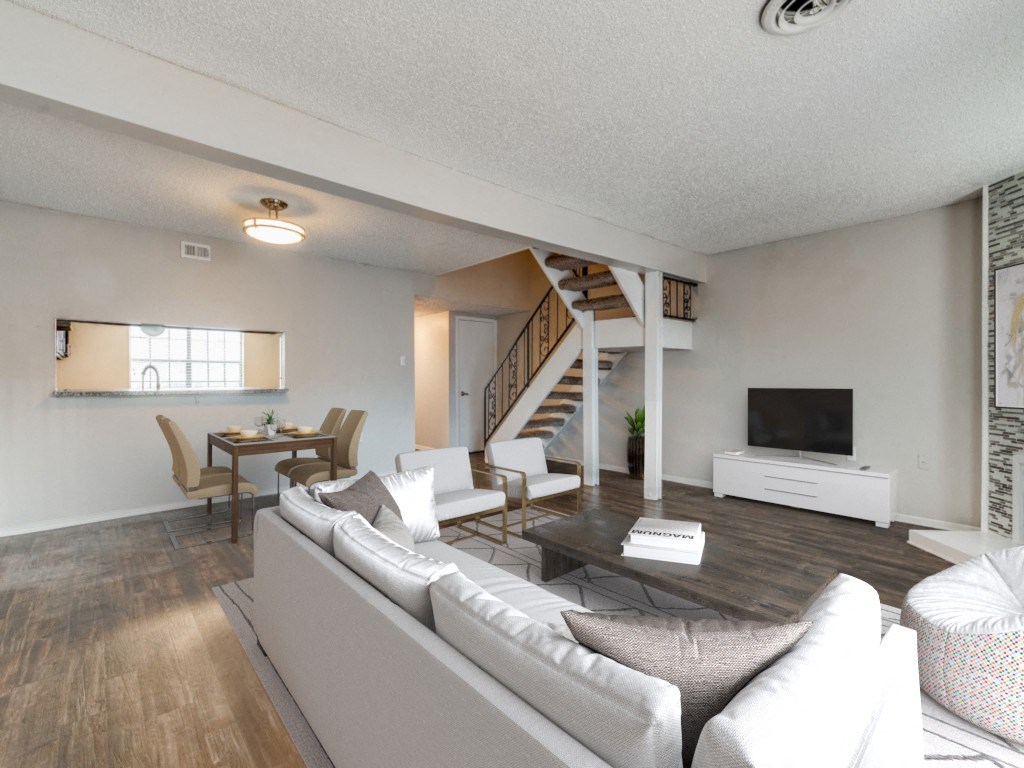 a living room with a couch and a table and a staircase