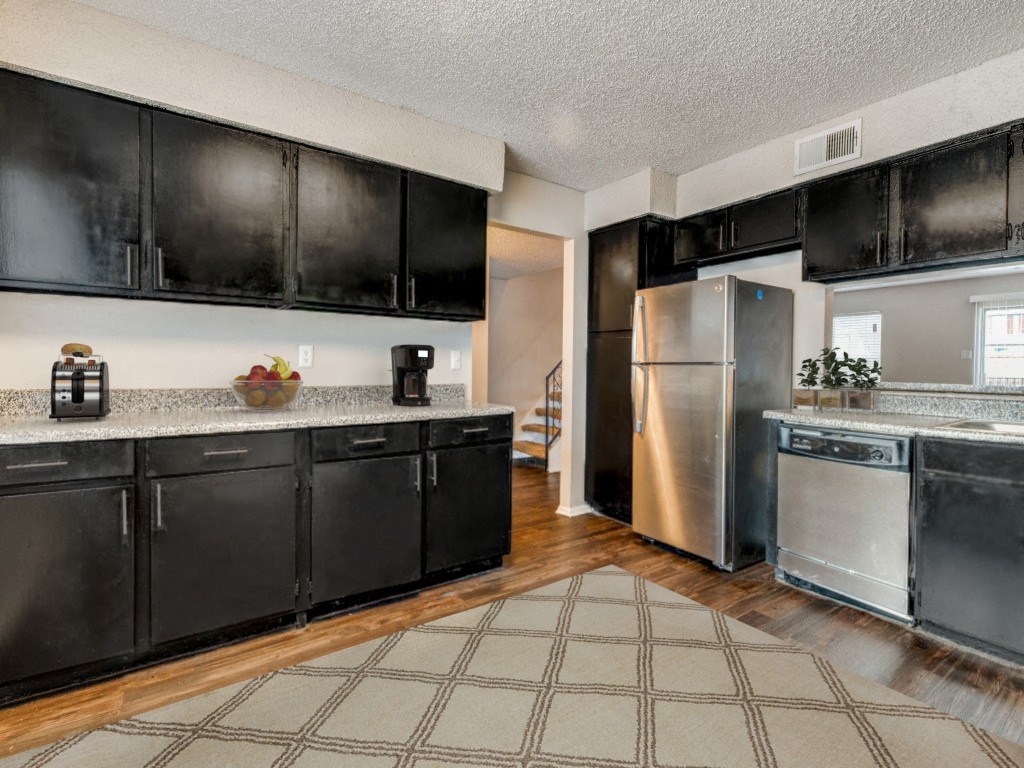 a large kitchen with stainless steel appliances and black cabinets