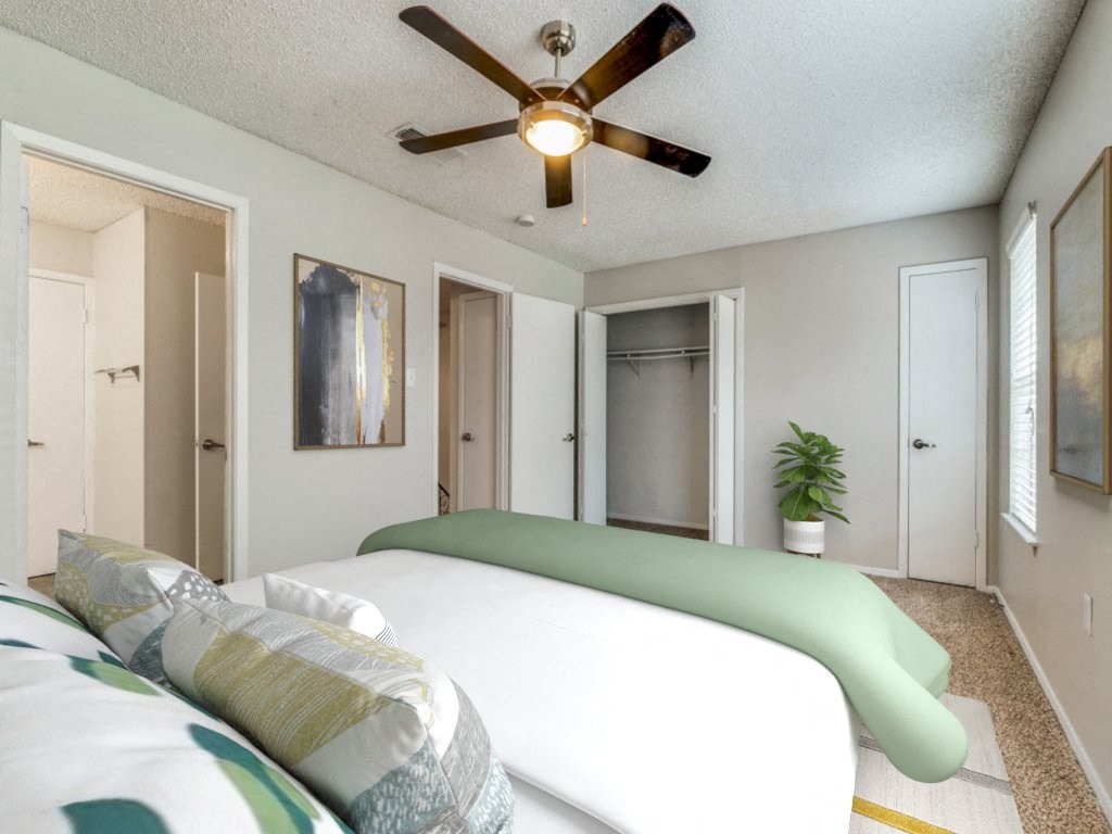 a bedroom with a large bed and a ceiling fan