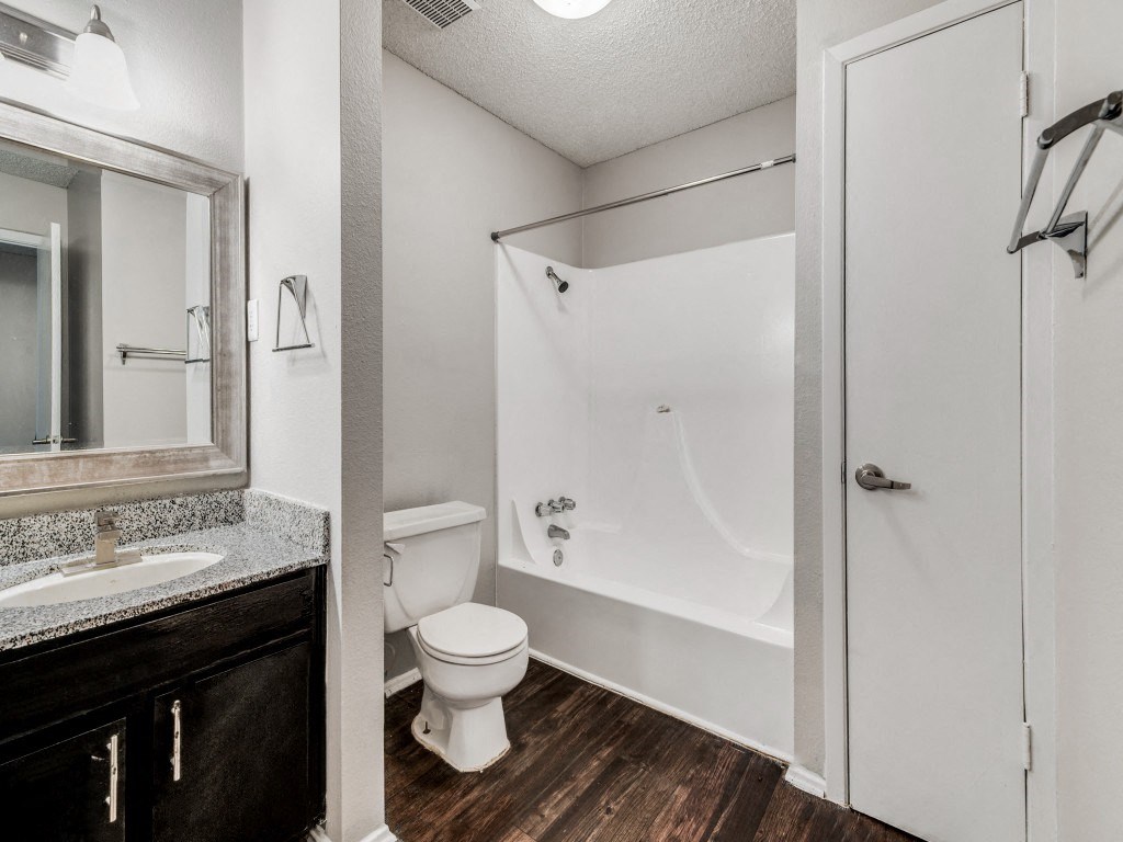 a bathroom with a white tub and toilet and a sink