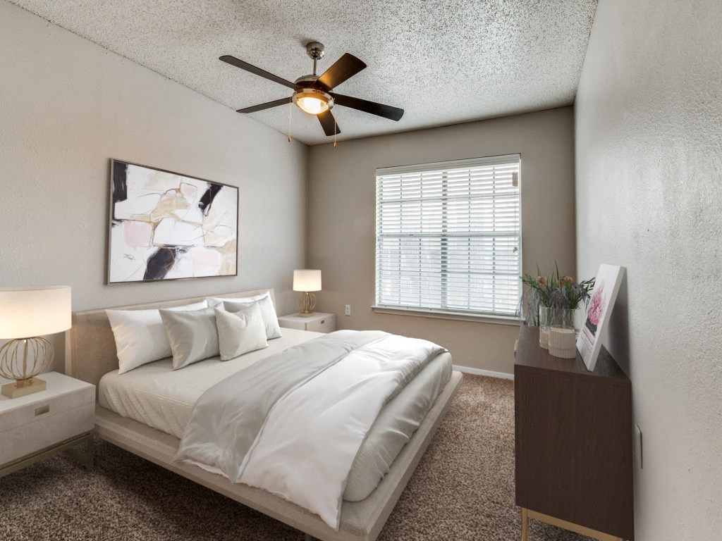 a bedroom with a large bed and a ceiling fan