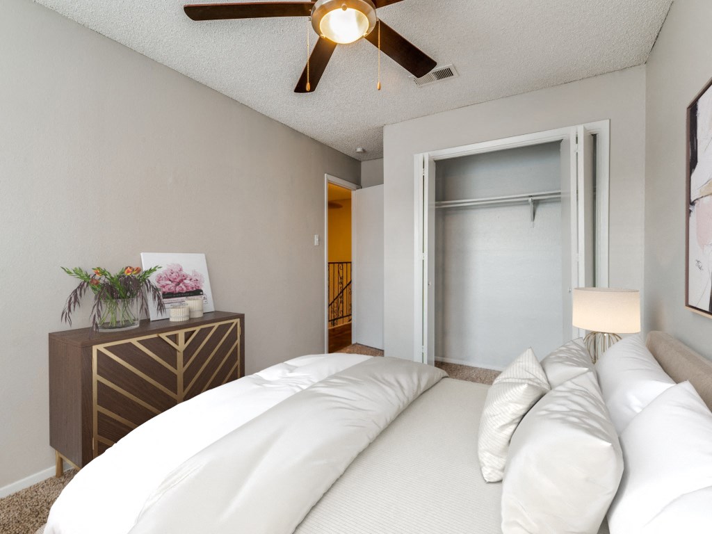 a bedroom with a large bed and a ceiling fan