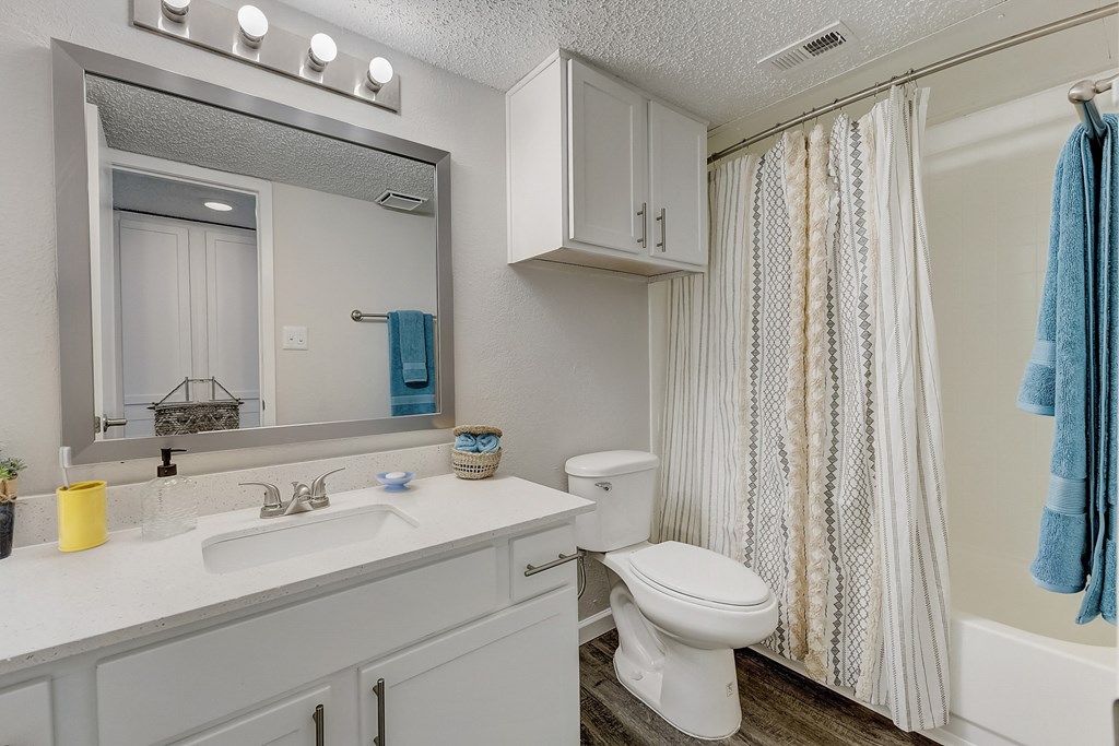 a bathroom with a white sink and toilet and a white shower curtain