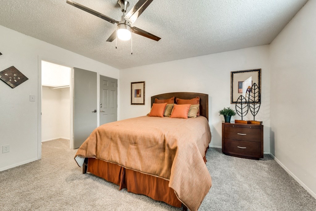 the master bedroom has a large bed and a ceiling fan
